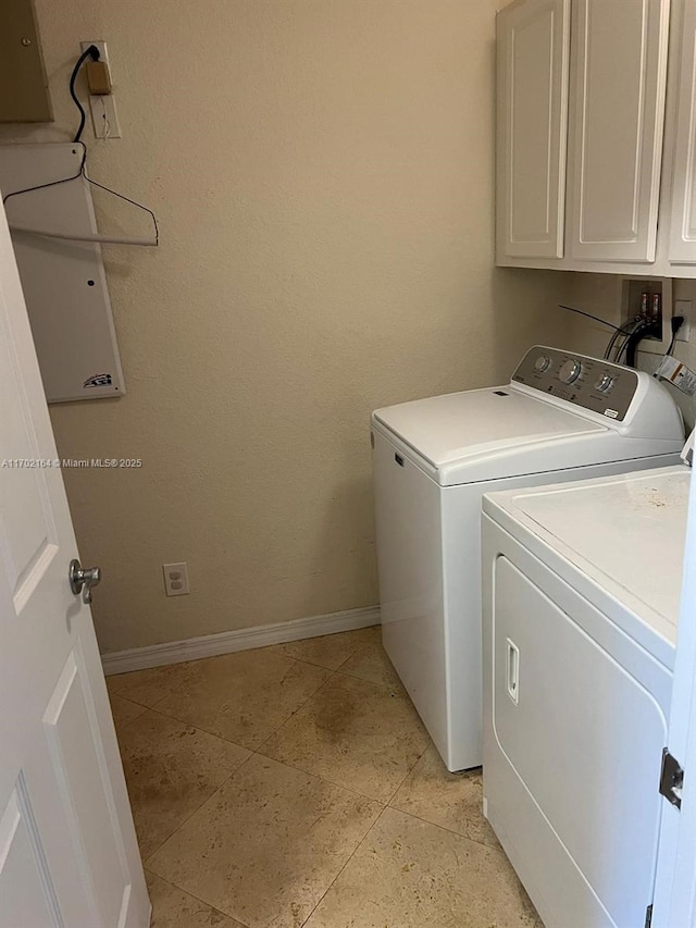 laundry room with light tile patterned floors, washing machine and dryer, and cabinets