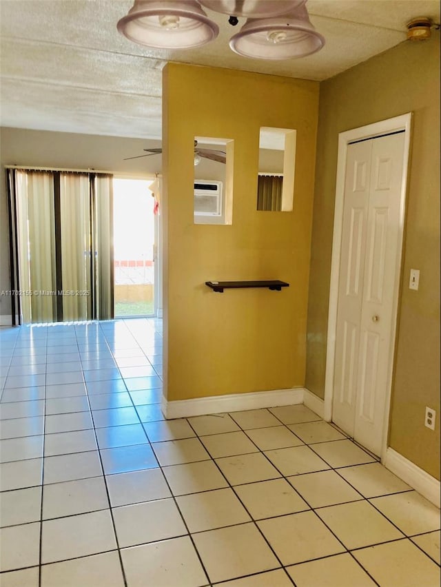 hallway with a textured ceiling and light tile patterned floors