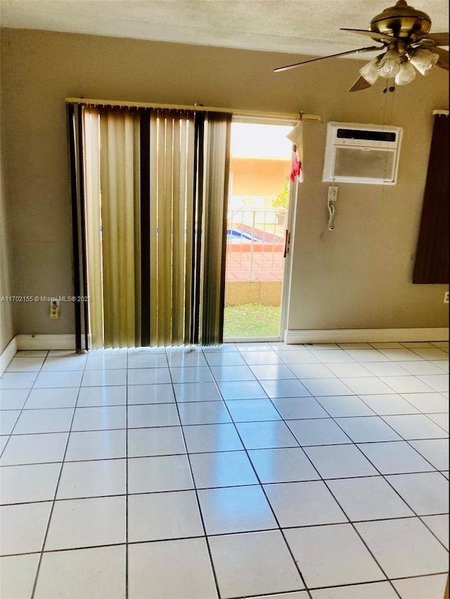 tiled empty room with a wall mounted air conditioner and ceiling fan