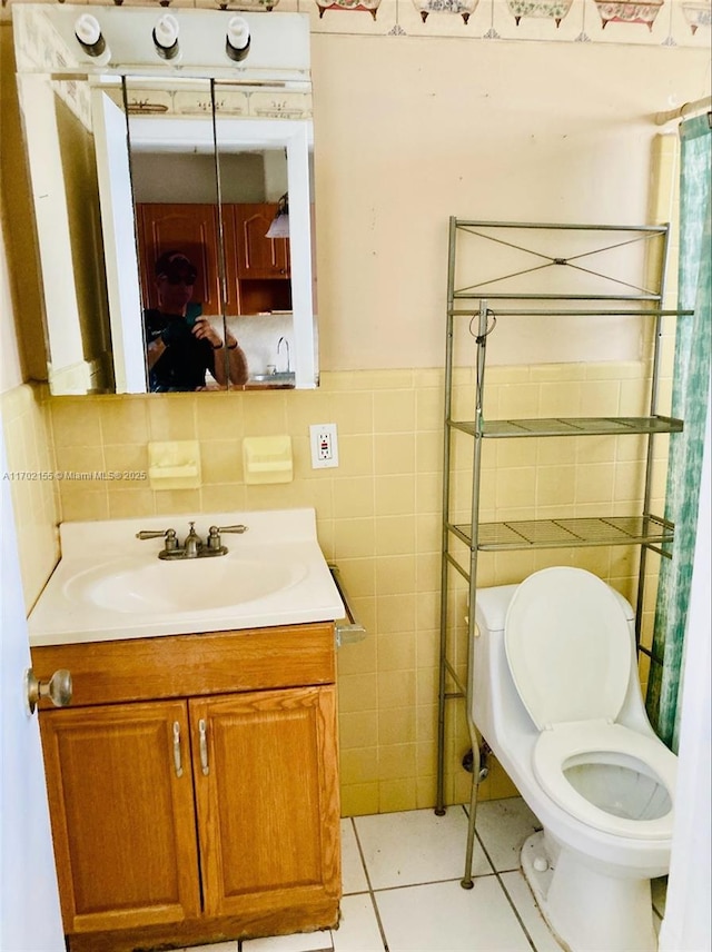 bathroom featuring vanity, tile patterned floors, tile walls, and toilet