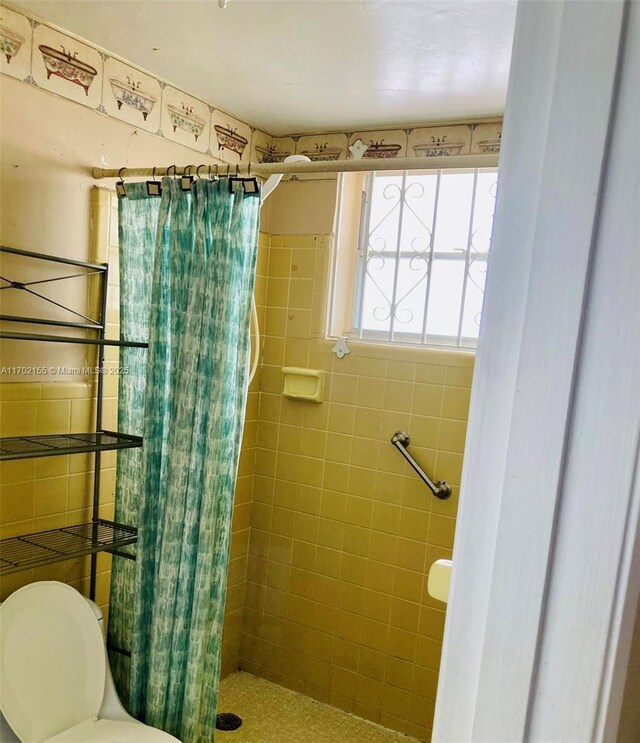 bathroom with curtained shower and toilet