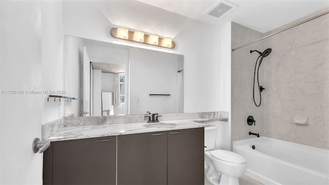 full bathroom featuring toilet, vanity, and tiled shower / bath