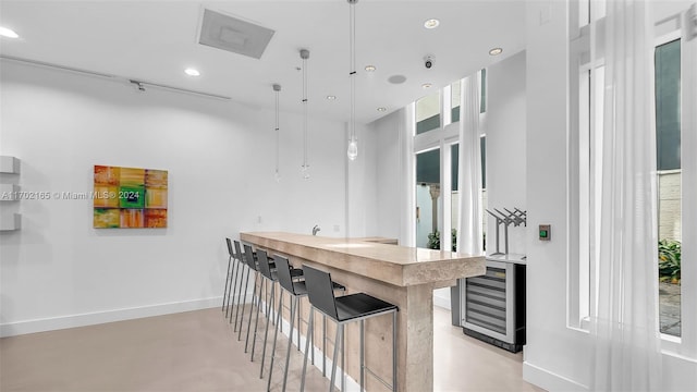 bar featuring hanging light fixtures and beverage cooler