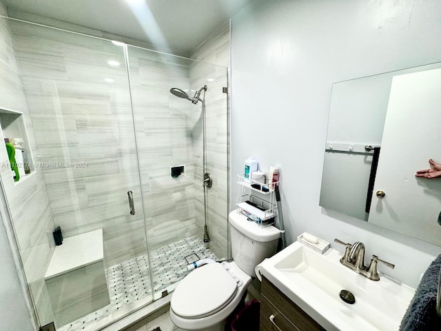 bathroom with vanity, toilet, and a shower with shower door