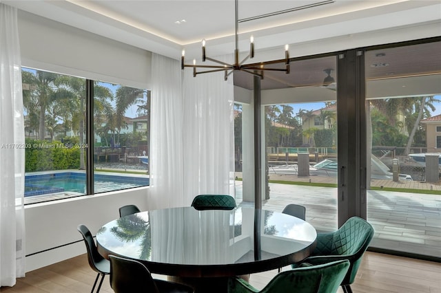 dining area with light hardwood / wood-style floors, an inviting chandelier, and plenty of natural light