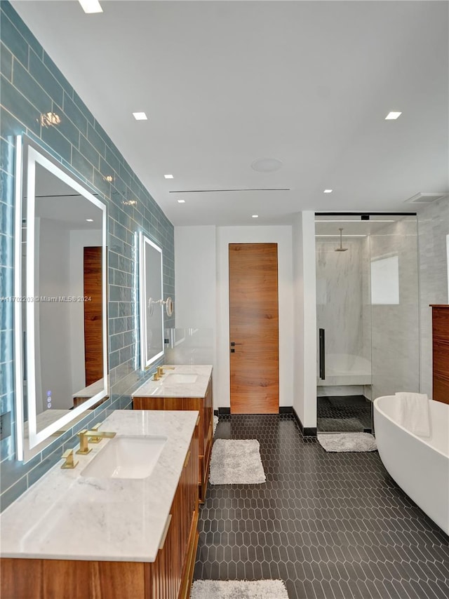 bathroom with plus walk in shower, vanity, and tile walls