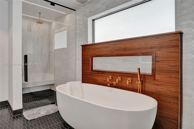 bathroom featuring tile patterned floors, tile walls, and independent shower and bath