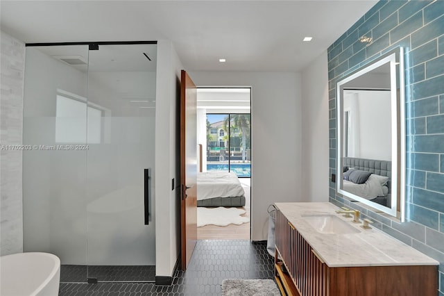 bathroom with vanity, shower with separate bathtub, and tile walls