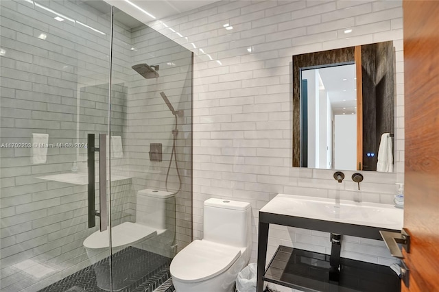 bathroom with toilet, tile walls, and a shower with shower door