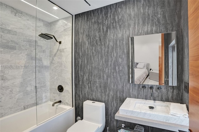 full bathroom featuring vanity, tiled shower / bath, and toilet