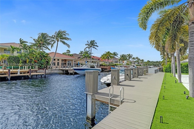 view of dock with a yard and a water view