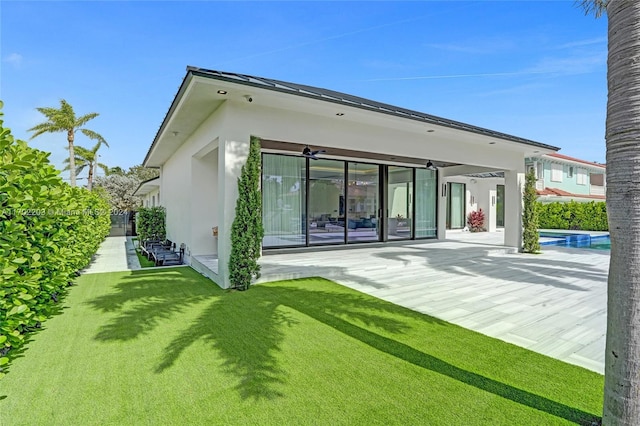 back of house featuring a lawn, a patio area, and ceiling fan