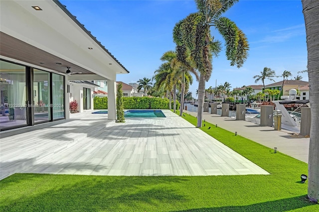 view of pool with a lawn and ceiling fan