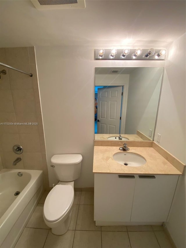 full bathroom with tile patterned flooring, vanity, toilet, and tiled shower / bath