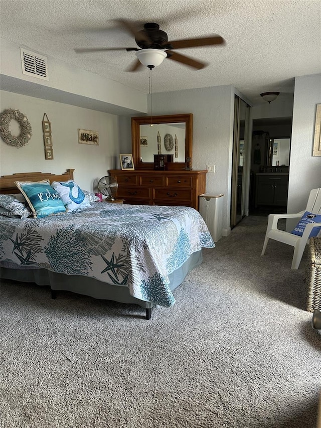 carpeted bedroom with ceiling fan and a textured ceiling