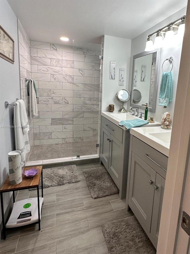 bathroom with vanity, wood-type flooring, and tiled shower