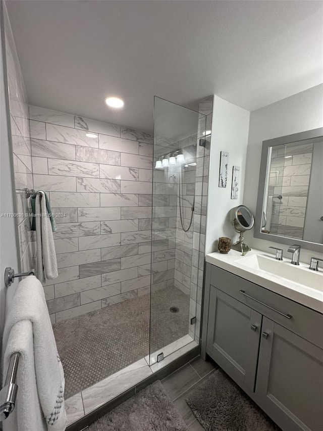 bathroom featuring a tile shower and vanity