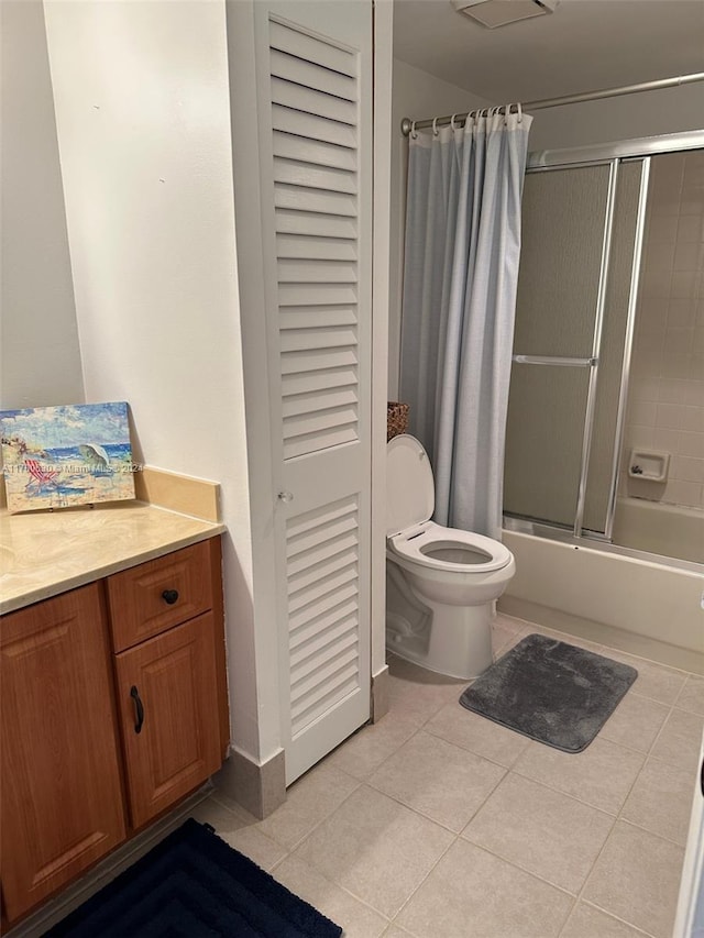 full bathroom with tile patterned floors, shower / bath combo with shower curtain, vanity, and toilet