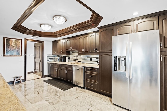 kitchen featuring a raised ceiling, appliances with stainless steel finishes, sink, and dark brown cabinets