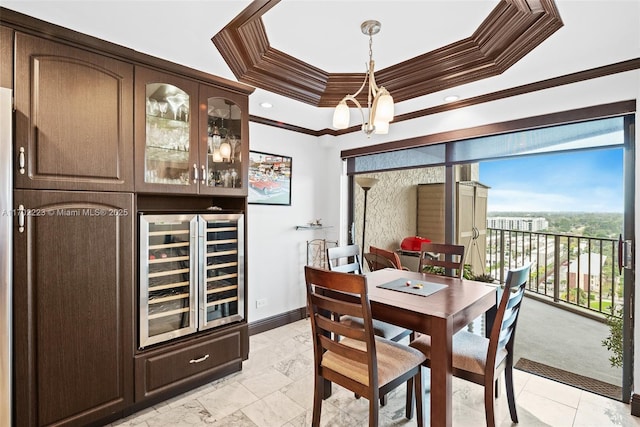 dining space featuring beverage cooler, a tray ceiling, and crown molding