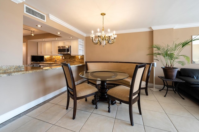 tiled dining space featuring a chandelier and ornamental molding