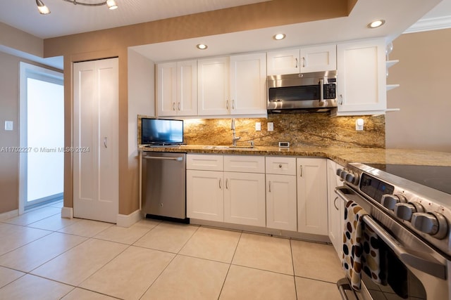 kitchen with white cabinets, appliances with stainless steel finishes, decorative backsplash, and stone counters