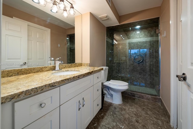 bathroom with vanity, toilet, and a shower with door