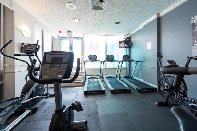 exercise room with a textured ceiling and ornamental molding