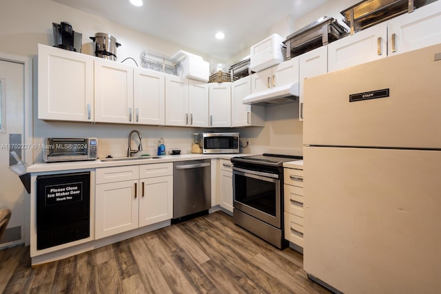 kitchen featuring white cabinets, appliances with stainless steel finishes, dark wood-type flooring, and sink