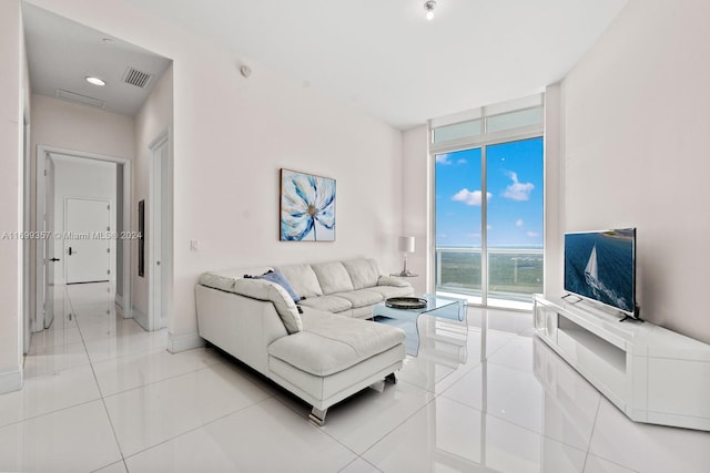 living room with floor to ceiling windows and light tile patterned floors