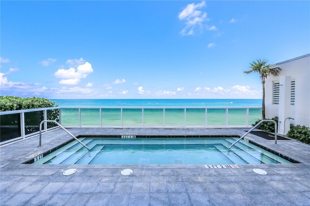 view of pool featuring a community hot tub and a water view