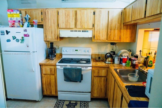 kitchen with light tile patterned floors, white appliances, and sink