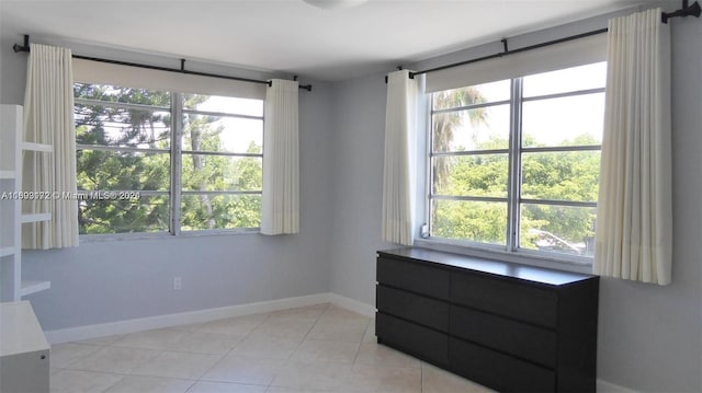 unfurnished room featuring plenty of natural light and light tile patterned flooring