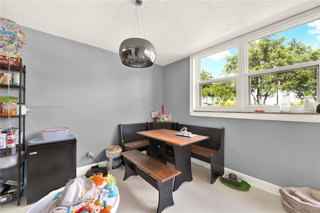 dining space featuring a textured ceiling