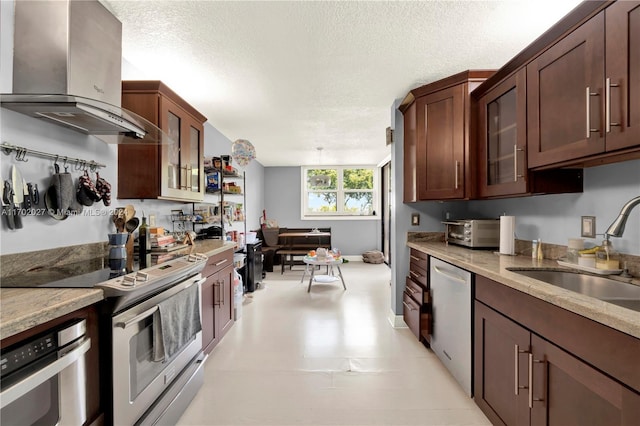 kitchen featuring light stone countertops, appliances with stainless steel finishes, wall chimney exhaust hood, a textured ceiling, and sink