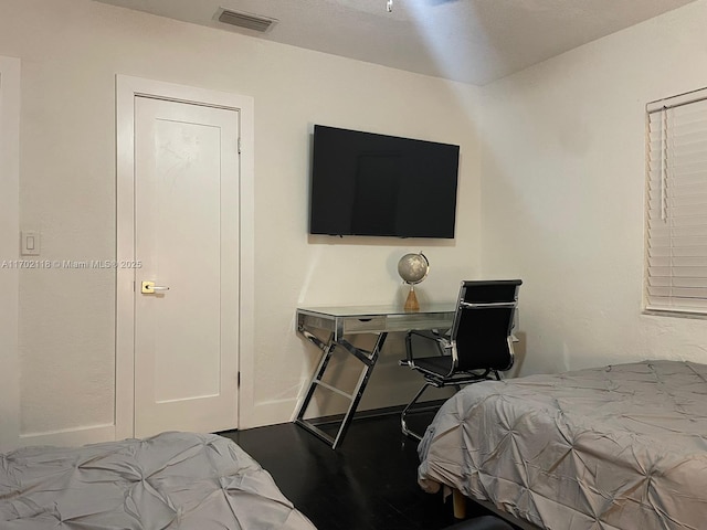 bedroom with visible vents and wood finished floors