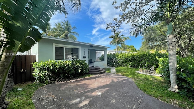 view of front facade featuring fence and stucco siding