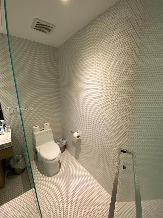 bathroom featuring tile patterned flooring, visible vents, and toilet