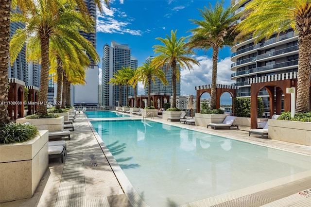 community pool with a patio area and a city view