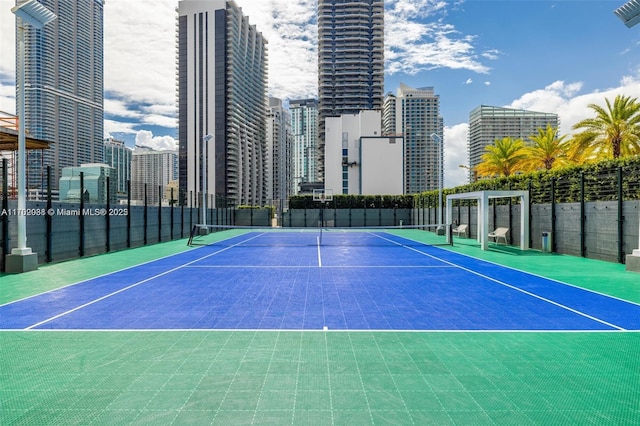 view of sport court with a city view, community basketball court, and fence