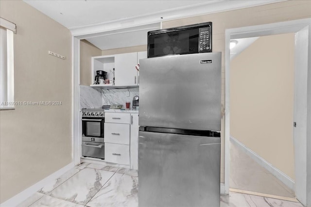 kitchen featuring white cabinets, backsplash, and appliances with stainless steel finishes