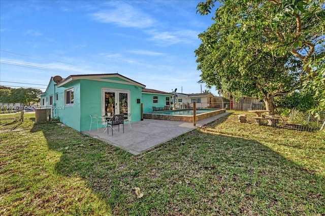 back of house with a fenced in pool, a yard, a patio, and central AC unit