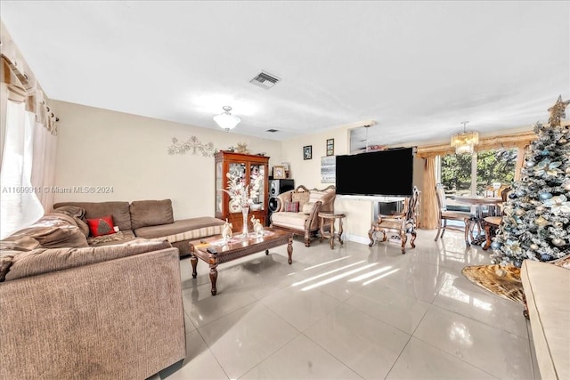 tiled living room featuring an inviting chandelier