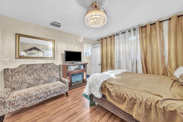 bedroom with hardwood / wood-style flooring and a notable chandelier