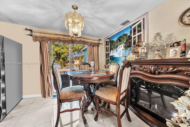 dining room with light tile patterned floors, a textured ceiling, and a chandelier