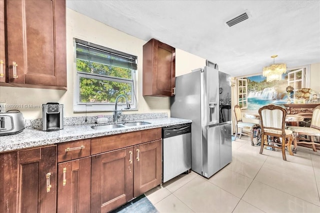 kitchen with light stone counters, light tile patterned floors, sink, and appliances with stainless steel finishes