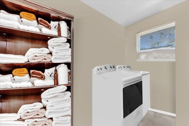 laundry room featuring separate washer and dryer and light tile patterned floors