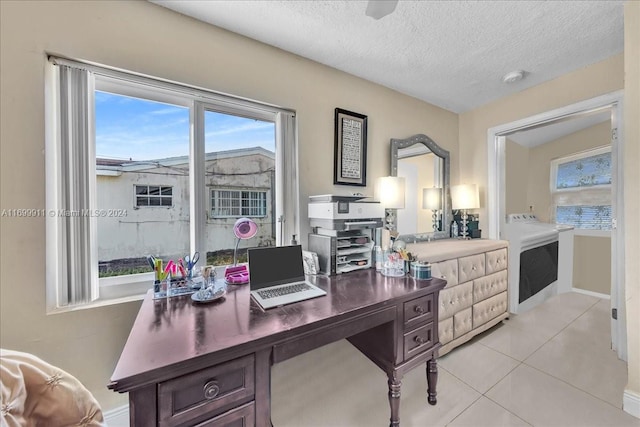 tiled home office featuring a textured ceiling and washer / clothes dryer