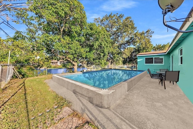 view of pool with a yard and a water view