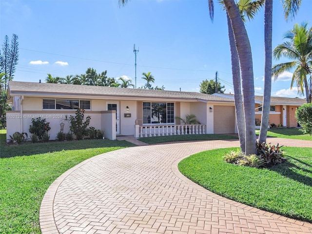 single story home with a porch, a garage, and a front yard